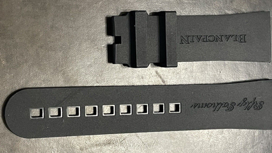 A black rubber watch strap featuring a small hole for adjustment, highlighting comfort options for rubber straps.