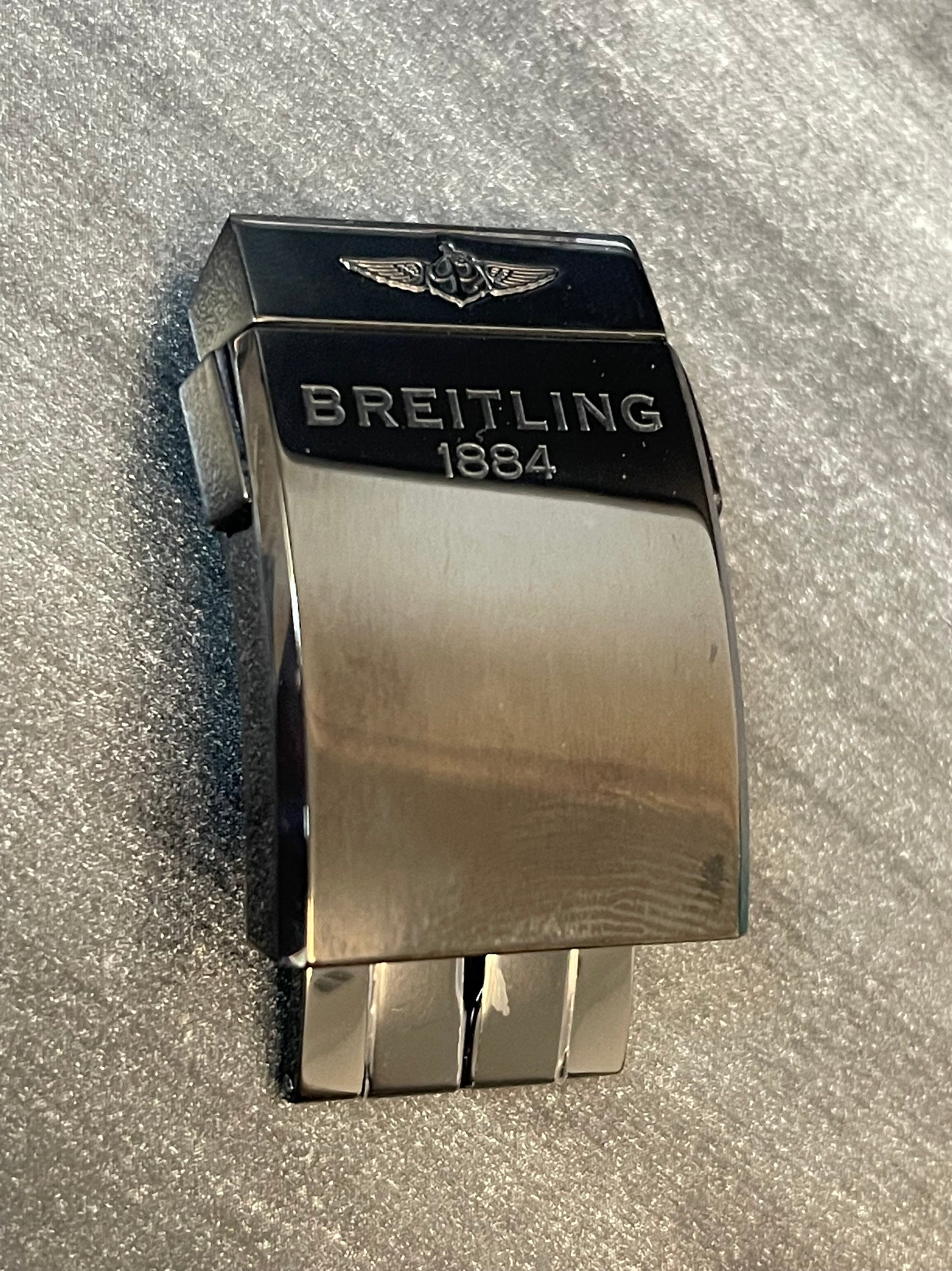 Breitling watch clasp featuring engraved Breitling 1884 on polished metal surface