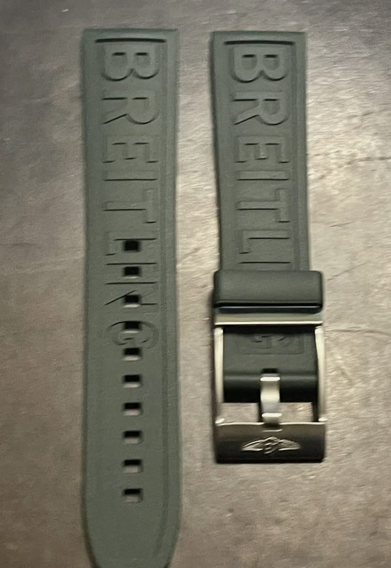 Blue AP watch strap featuring branding and deployment clasp displayed over luxury watch face