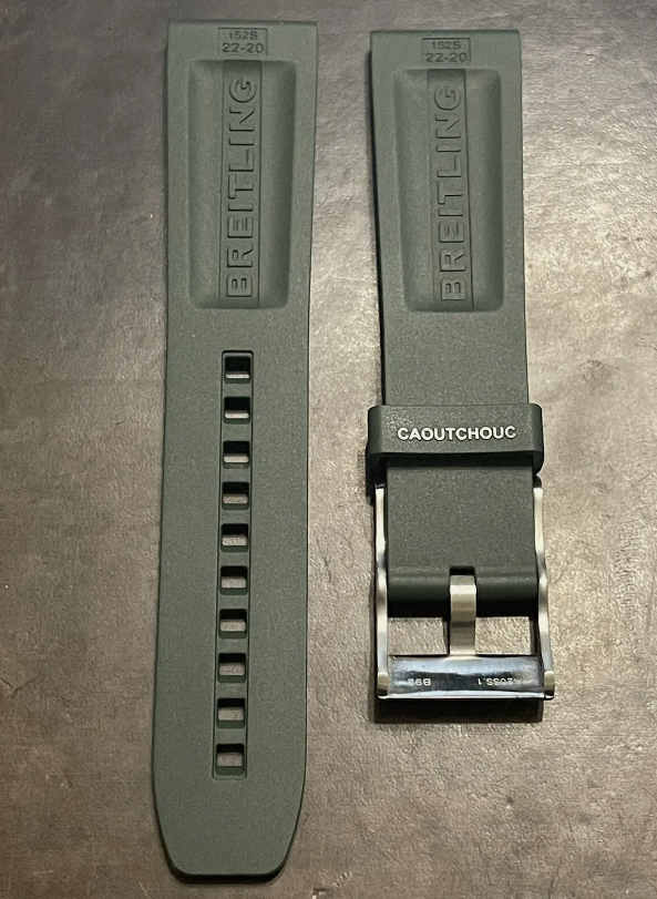Breitling green rubber watch strap with logo and metal buckle laid flat