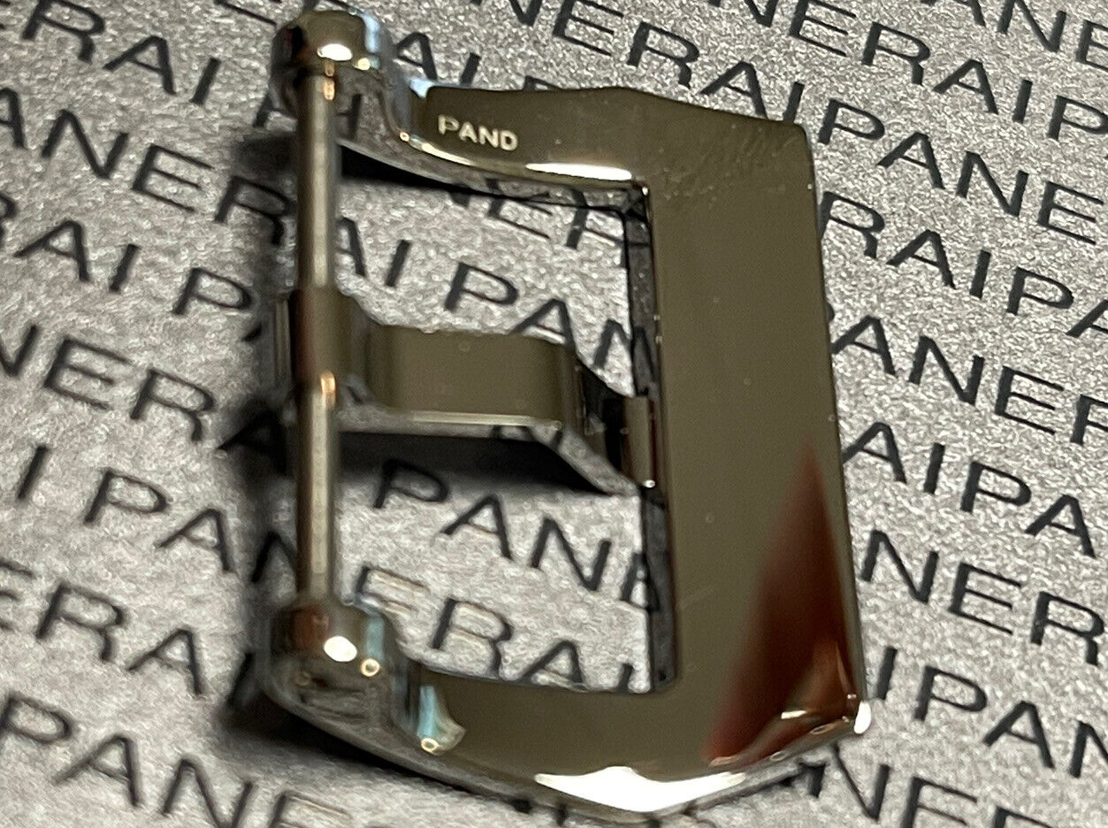 Close-up of a shiny stainless steel Panerai watch buckle against a textured background featuring repeated "PANERAI" branding.