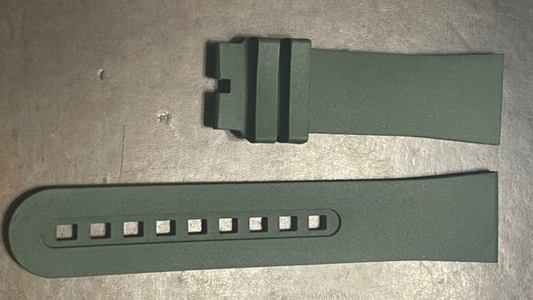 A pair of green Blancpain rubber watch straps displayed on a table, emphasizing their vibrant color and material.