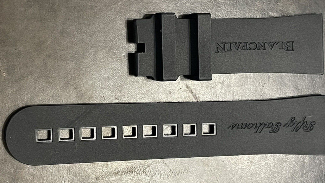 A black rubber watch strap featuring a small hole for adjustment, highlighting comfort options for rubber straps.