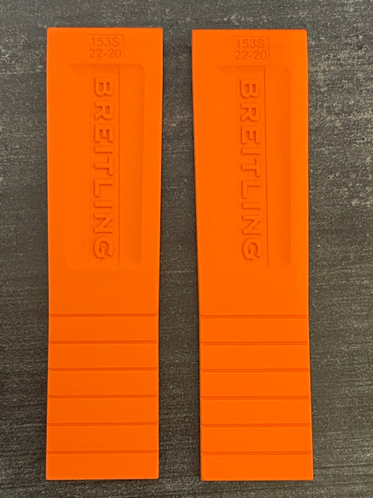 A pair of orange rubber wristbands displayed on a table.