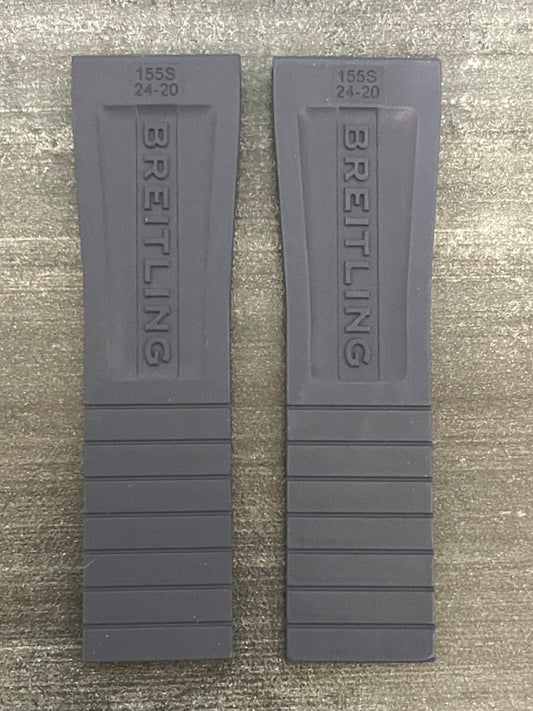 A pair of gray plastic watch straps displayed on a table.