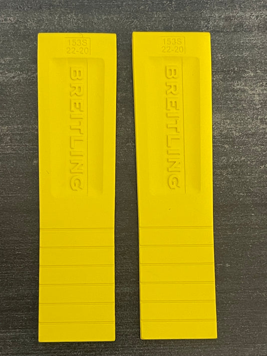 Two yellow rubber bands labeled "breathing" resting on a white surface.